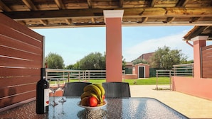 A covered outdoor area with a table, chairs, and a bottle of wine. - Fior Di Roda - Accessible facilities (Roda)