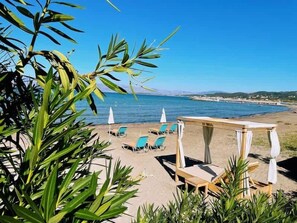 A beachside seating area with lounge chairs and umbrellas, overlooking the sea. - Fior Di Roda - Accessible facilities (Roda)