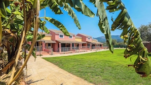 A two-story building with a tiled roof and a paved walkway leading to a grassy lawn. - Fior Di Roda - Accessible facilities (Roda)