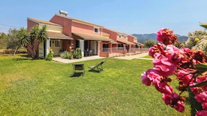A two-story house with a tiled roof, a covered patio, and a well-maintained lawn. - Fior Di Roda - Accessible facilities (Roda)