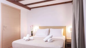 A bedroom with a bed, pillows, a nightstand, a potted plant, and a door. - Fior Di Roda - Accessible facilities (Roda)
