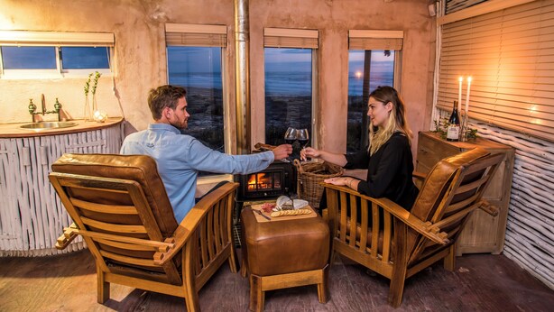 A cozy room with a fireplace, wooden furniture, and a view of the outdoors.