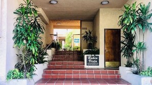 Una escalera conduce a la entrada de un edificio, con un letrero que dice 'Bella Vista Condominiums'.