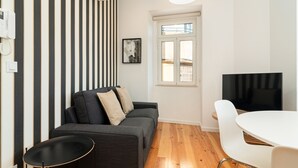 Een moderne woonkamer met een bank, een eettafel en een televisie.