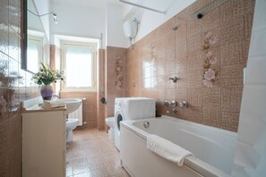 A bathroom with a bathtub, toilet, sink, and washing machine. - Roman Style II near San Pietro - 10 minutes from Vatican and St Peter's Basilica (Roma)
