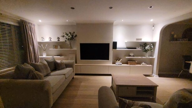 A modern living room with a sofa, coffee table, and TV mounted on the wall. - 3 Bedroom, Sleeps 6, Free Parking (Glasgow)