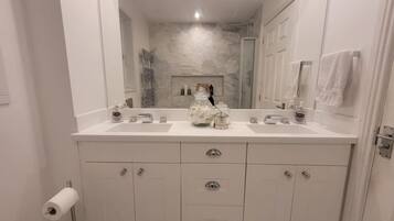 A bathroom with two sinks, a mirror, and storage cabinets.