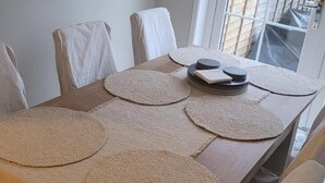 A dining table with round placemats and stacked plates, surrounded by chairs. - 3 Bedroom, Sleeps 6, Free Parking (Glasgow)