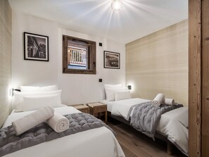 Ein Hotelzimmer mit zwei Betten, einem kleinen Tisch und einem Fenster.