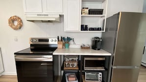 A compact kitchen with a built-in oven, a microwave, and a refrigerator.