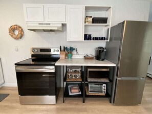 A compact kitchen with a built-in oven, a microwave, and a refrigerator.