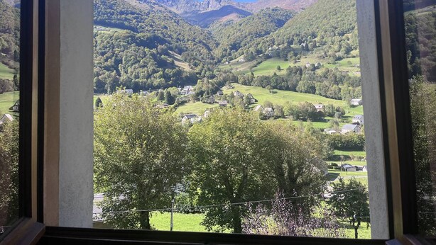 A view of a valley with houses and mountains.