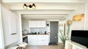 A compact living space with a kitchenette, a dining area, and a seating area. - Superbe appartement duplex - Vue mer - Piscine (Guidel)