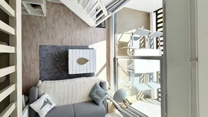 A modern bedroom with a built-in bed, a large window, and a staircase. - Superbe appartement duplex - Vue mer - Piscine (Guidel)
