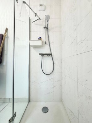 Regadera, secadora de cabello, papel de baño 