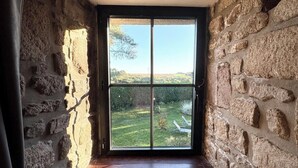 A room with stone walls, a large sliding glass door, and a wooden floor.