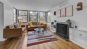 A modern living room with a brown leather sofa, a round coffee table, and a fireplace.