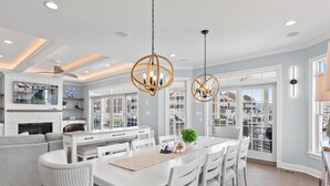 Una cocina moderna con armarios blancos, una isla central e iluminación colgante.