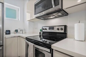 Eine moderne Küche mit Edelstahlherd, Mikrowelle und Backofen.