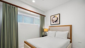A hotel room with a bed, curtains, a window, a wall-mounted artwork, and a bedside lamp. - Poolside Bliss: 2-Bedroom Condo with Patio Noord (Noord)