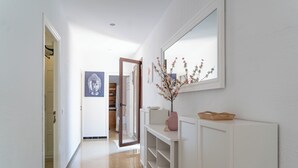 A hallway with a white console table, a mirror, and a vase with flowers. - El Ranchito, villa in Paguera, Majorca, quiet area, with swimming pool and barbecue. (Peguera)