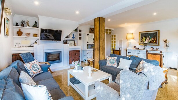 A spacious living room with a fireplace, sofas, a coffee table, and a TV. - El Ranchito, villa in Paguera, Majorca, quiet area, with swimming pool and barbecue. (Peguera)