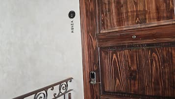 A wooden door with a metal handle and a metal railing with decorative elements.