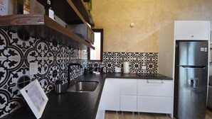 A kitchen with patterned backsplash, stainless steel appliances, and a wooden countertop. - Loft Pienza 6 (Val'Quirico)