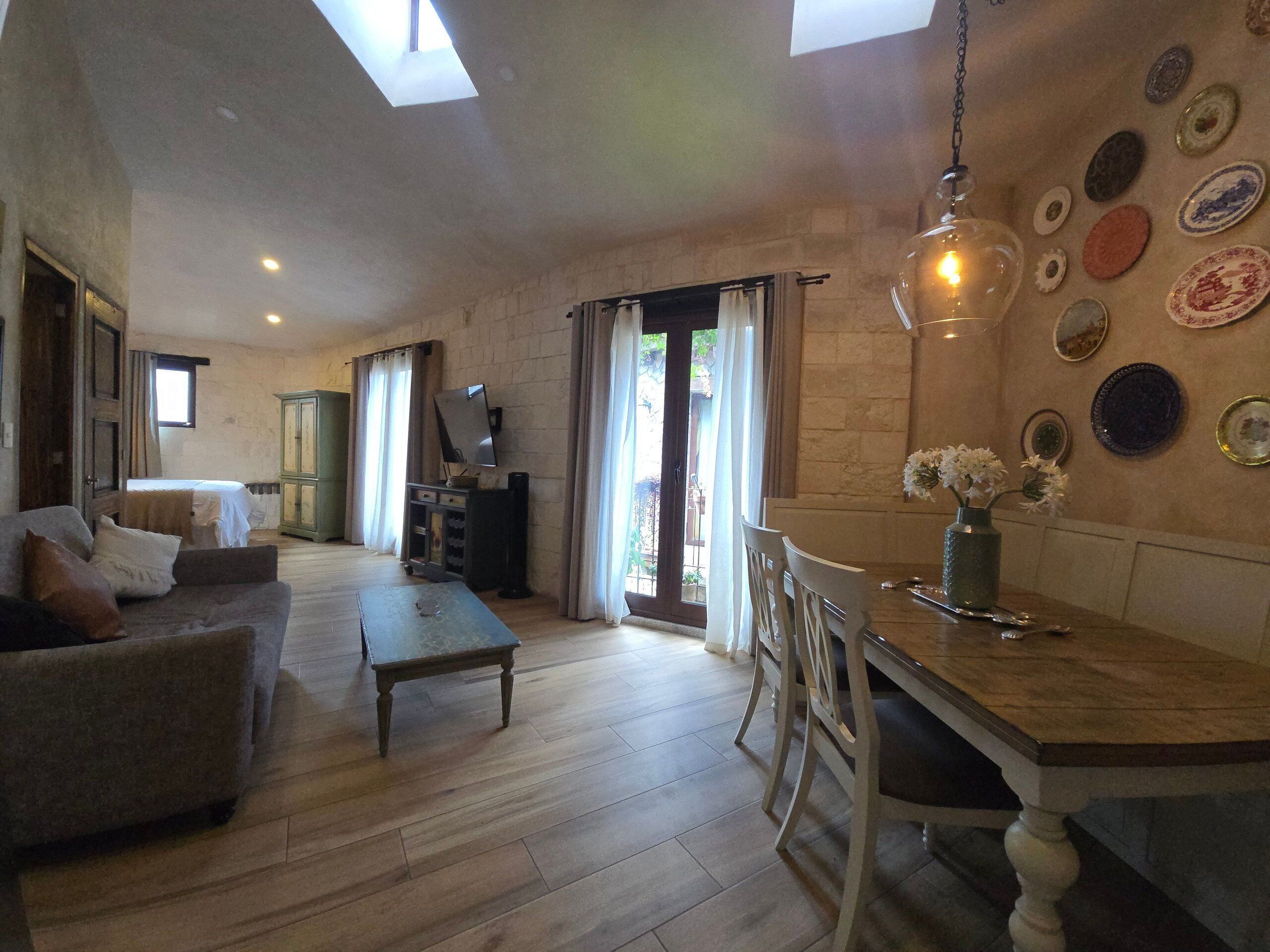 A spacious living area with a sofa, a dining table, and a TV.