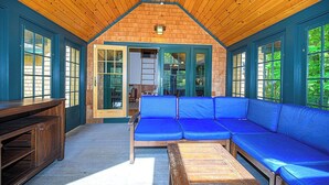 Un interior de madera con un sofá azul, un banco de madera y una mesa.