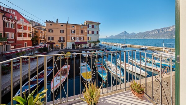 Une ville côtière aux bâtiments aux couleurs vives, un port de plaisance rempli de bateaux et une montagne en arrière-plan.