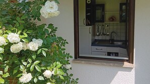 A small window view of a kitchen with a sink, cabinets, and a microwave. - Alexa, the cozy bright vacation apartment in Überlingen, 10 minutes walk to the lake (Überlingen)
