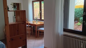A room with a wooden bunk bed, a dining table with chairs, a window with curtains, and a view of the outside. - Alexa, the cozy bright vacation apartment in Überlingen, 10 minutes walk to the lake (Überlingen)