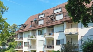 A multi-story residential building with balconies, a garden area, and a clear blue sky. - Alexa, the cozy bright vacation apartment in Überlingen, 10 minutes walk to the lake (Überlingen)
