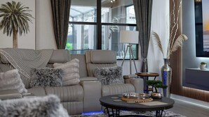 A modern living room with a sofa, a coffee table, and a TV. - Immersive Activities, Arcade, Theatre Sleeps 24 (Davenport)