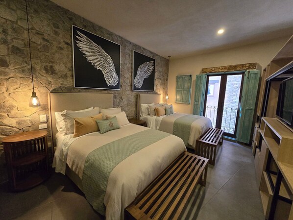 Un dormitorio con dos camas, una pared de piedra y una obra de arte con alas.