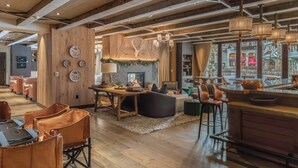 A spacious, modern interior with wooden beams, a fireplace, and a bar area. - Auberge Resort 5 Star Residence (Mountain Village)