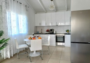 Fridge, electric kettle, cookware/dishes/utensils, dining tables