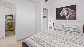 A bedroom with a bed, a ceiling fan, a tiger artwork, and a closet. - Sleek 2-Bed 1-Bath Home • Near Fort Bliss (El Paso)