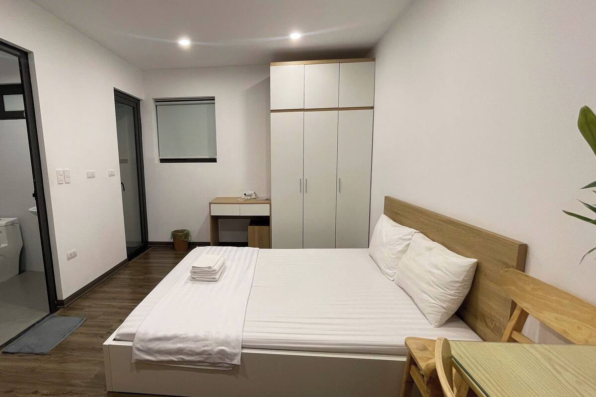 Una habitación de hotel con cama, escritorio, armario y baño.