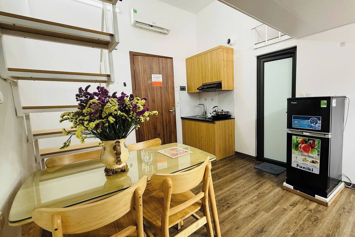Una cocina compacta con armarios de madera, estufa integrada y refrigerador.