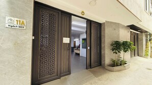 L’entrée d’un hôtel au design moderne, avec une porte aux motifs géométriques et une enseigne indiquant le numéro de chambre 11A.