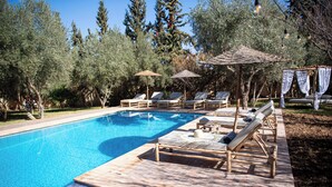 A pool area with lounge chairs and umbrellas.