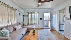 Ein Wohnzimmer mit Sofa, Couchtisch und Deckenventilator.