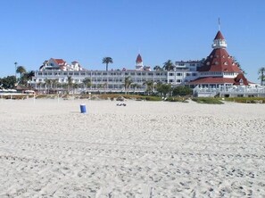 A beachfront hotel with a prominent red-roofed tower and multiple balconies. - South Park 1 House 2 Full Apartments w Laundry (San Diego)