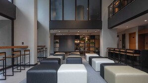 A modern interior with seating areas, a central table, and a mezzanine level. - New, comfortable, excellent location. In Barra: beach, pool and carnival (Barra Salvador)