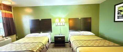 A hotel room with two beds, a nightstand with lamps, and a window with curtains.