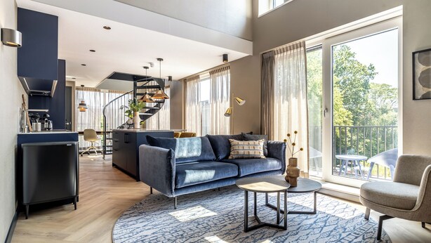 A modern living room with a sofa, coffee table, and a view of the outdoors. - BizStay Delft  (Delft)