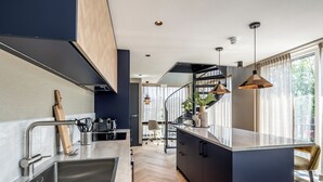 A modern kitchen with a built-in island, stainless steel appliances, and pendant lighting. - BizStay Delft  (Delft)