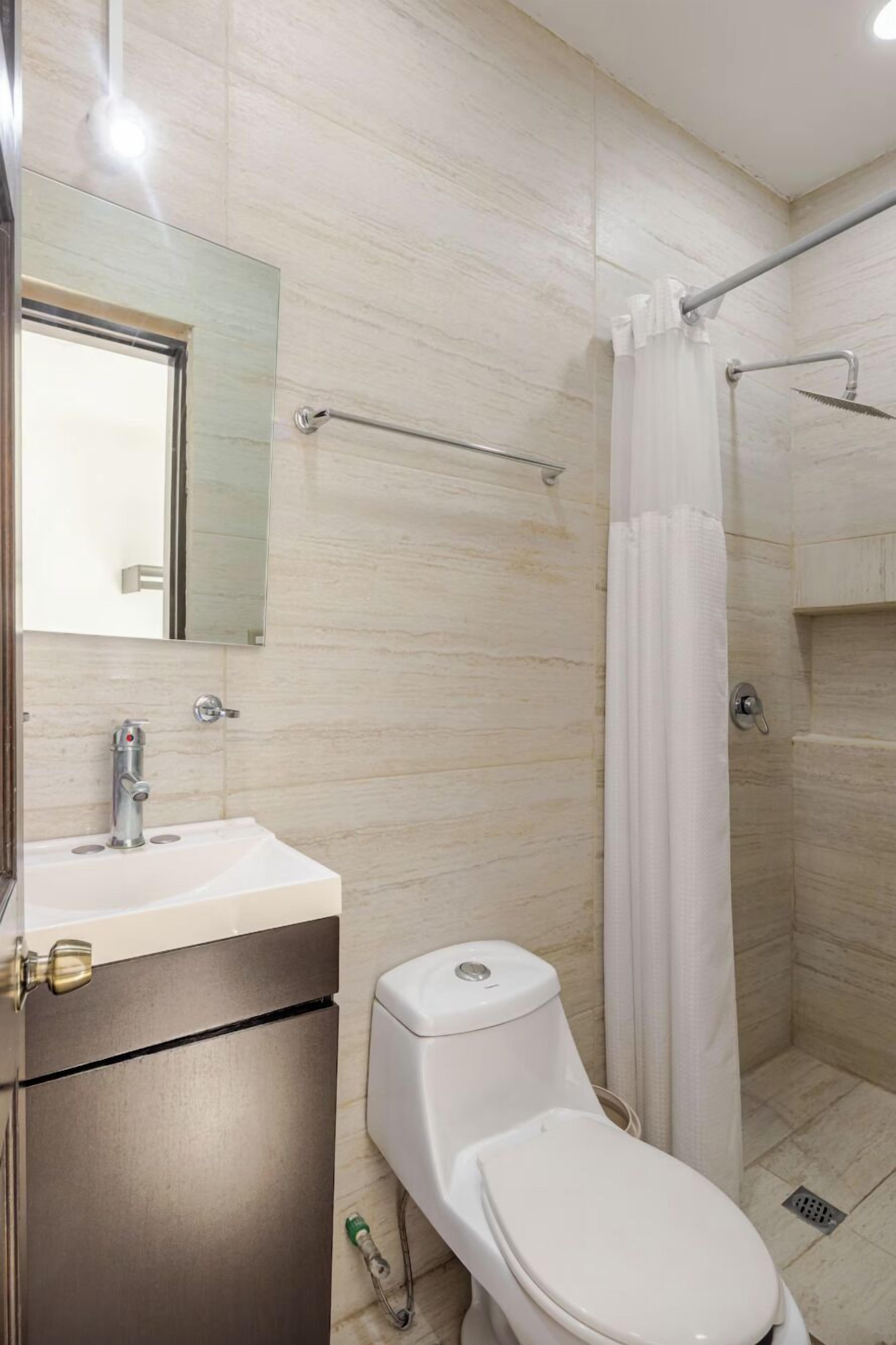 A bathroom with a toilet, sink, and shower.